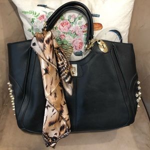 Black shoulder bag with gold spikes